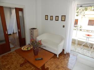 a living room with a white chair and a table at Zira Holiday House in Makrygialos