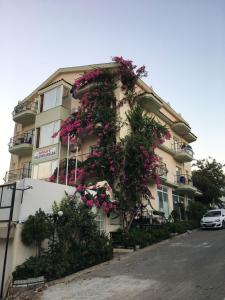 a building with pink flowers on the side of it at Yalcinkayalar Aparthotel in Datca