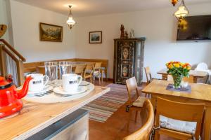 Almhaus Alpenrose في Seidegg: مطبخ وغرفة طعام مع طاولة وكراسي