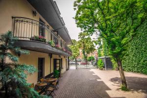 克拉科夫的住宿－諾布爾敦酒店，街道上,有带阳台和树的建筑