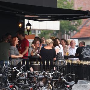 a group of people sitting at a bar looking at bikes at smartel at The Unbrexit in Ahaus