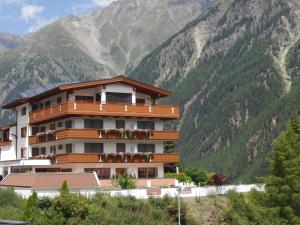 a building with flowers on the balconies in front of a mountain at Haus Amaris in Sölden