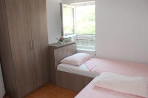 ein kleines Schlafzimmer mit zwei Betten und einem Fenster in der Unterkunft Vila Apartment in Poljica