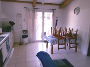 een keuken met een tafel en stoelen in een kamer bij Mini Villa à 100m de la mer avec prise de recharge élec privative in Sari Solenzara