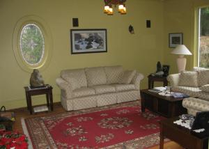a living room with a couch and a red rug at Sasquatch Crossing Eco Lodge B&B in Harrison Mills