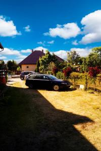a black car parked in the yard of a house at Zefirek in Stegna