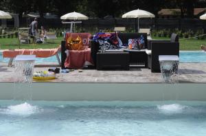 a fountain in a swimming pool with chairs and a table at Camping Listro in Castiglione del Lago