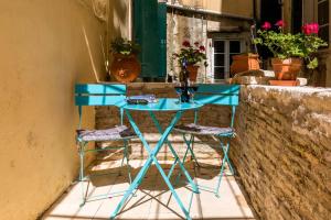 une table bleue et deux tabourets à côté d'un mur dans l'établissement Kantouni Bizi Myranthis Apartment, à Corfou