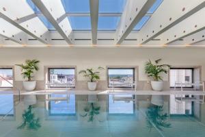 a swimming pool with plants in a building at Barceló Torre de Madrid in Madrid