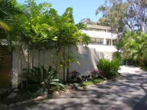 a house with a fence next to a street at Cove Point in Noosa Heads