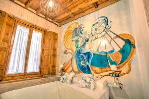 a bedroom with a painting on the wall at Casa Meninas y Anillo Apartamentos Deluxe MeninasCollection in Toledo