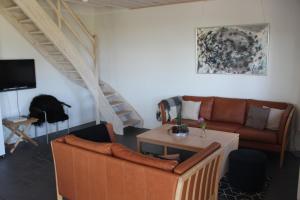 - un salon avec un canapé et une table dans l'établissement Skelgaard Ferielejlighed, à Jelling