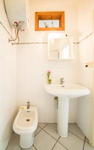 ein weißes Bad mit einem Waschbecken und einem WC in der Unterkunft Latte&Miele in Ragusa
