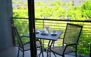 a table and chairs on a balcony with a view at Rogalux Blue in Tbilisi City