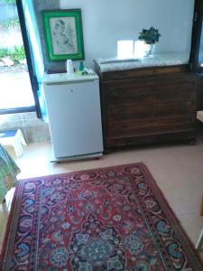 een woonkamer met een koelkast en een tapijt bij L'impossibile Guesthouse in Appiano Gentile