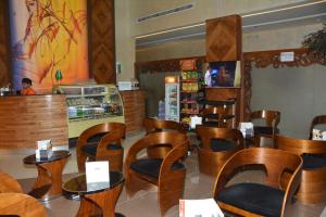 a restaurant with wooden chairs and tables and a counter at Mandarin Hotel Apartments in Riyadh