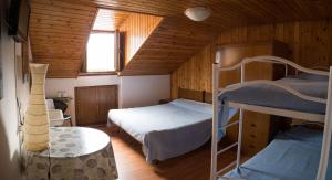 1 dormitorio con 2 literas y mesa en B&B Edelweiss, en Castione della Presolana