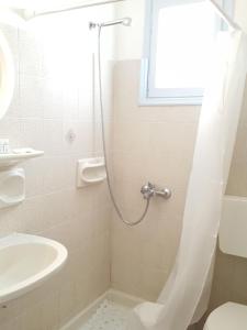 a bathroom with a shower and a toilet and a sink at Villa Dioni in Kamari +68 photos