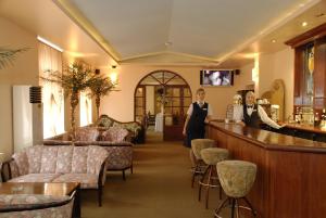 dos mujeres de pie en un bar en el vestíbulo del hotel en Sakhalin Sapporo Hotel, en Yuzhno-Sakhalinsk