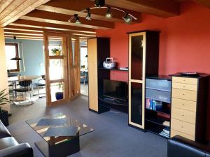 a living room with orange walls and a glass table at Ferienwohnung in Linden in Windelsbach