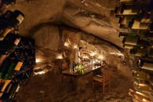 a man standing in a cave with a table with wine bottles at Six Senses Ninh Van Bay in Ninh Van Bay