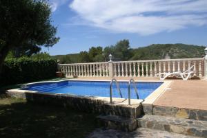 a swimming pool in a yard with a white fence at La torre in Rodonyà