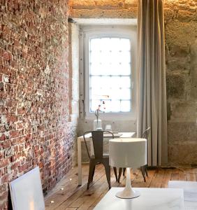 ヴィゼウにあるElementのレンガの壁、テーブルと椅子が備わる客室です。