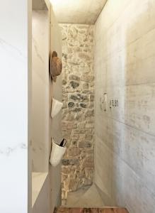 a bathroom with a stone wall and a walk in shower at Element in Viseu