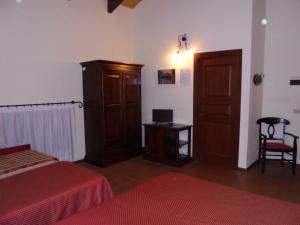 ein Schlafzimmer mit einem Bett, einem Schrank und einem Schreibtisch in der Unterkunft Ai Vecchi Crateri in SantʼAlfio