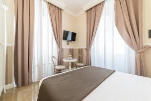 une chambre d'hôtel avec un lit et une table avec des chaises dans l'établissement Le Chiavi di Roma, à Rome