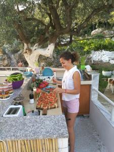 una mujer parada en una cocina preparando comida en Piqeras Relax Guest House, en Piqeras