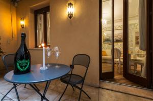 a bottle of wine sitting on a table with two glasses at Royal Giardini dell'Arena Relais - Royal Welcome in Verona