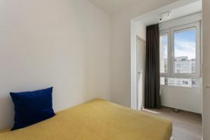 1 dormitorio con una almohada azul y una ventana en Apartment V7 en Ostende