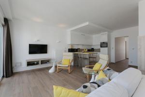 a living room with a white couch and a kitchen at Apartment V7 in Ostend
