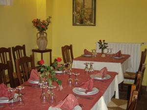 een eetkamer met 2 tafels met rode servetten en bloemen bij Ai Vecchi Crateri in SantʼAlfio