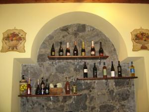 a wall with shelves filled with bottles of wine at Ai Vecchi Crateri in SantʼAlfio