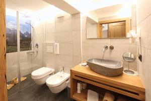a bathroom with a sink and a toilet at Obersanterhof in Sesto +34 photos