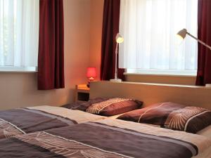 ボルテンハーゲンにあるModern Apartment near Sea in Ostseebad Boltenhagenのベッド2台(窓、カーテン付)が備わるベッドルーム1室