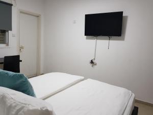 
a television and a bed in a room at Airport Guest House in Or Yehuda

