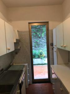 une cuisine avec une grande fenêtre et une porte dans l'établissement Appartamento con super vista sul mare, à Arenzano