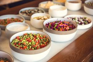 a table with bowls filled with different types of vegetables at Prima Tel Aviv Hotel in Tel Aviv
