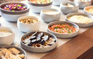 a table topped with bowls of different types of food at Prima Tel Aviv Hotel in Tel Aviv