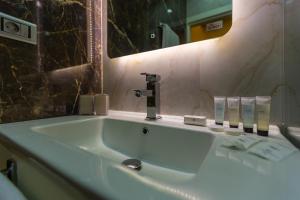 a bathroom sink with a faucet and a mirror at Aksent Hotel in Baku +37 photos
