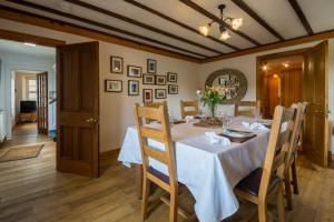 a dining room with a white table and chairs at The Ferry House Cottage in Aberfeldy