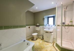 een badkamer met een bad, een toilet en een wastafel bij The Ferry House Cottage in Aberfeldy