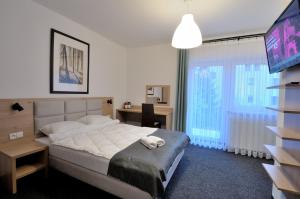 sypialnia z łóżkiem i telewizorem w obiekcie Willa Centrum w Zakopanem