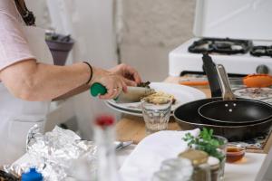 Eine Person steht in einer Küche und bereitet Essen zu in der Unterkunft Liotopi in Olympiada