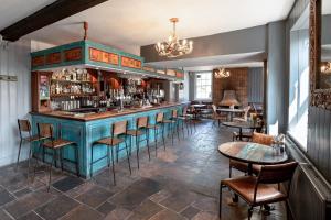 um bar com cadeiras e mesas num quarto em Elephant Hotel em Pangbourne