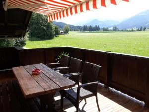 drewniany stół i krzesła na tarasie z widokiem na pole w obiekcie Appartement Müllner w mieście Kirchdorf in Tirol