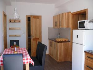 a small kitchen with a table and a white refrigerator at Sára Apartman in Hévíz